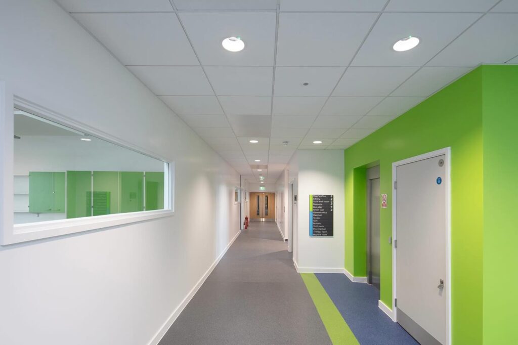 An image of one of the corridors in Emanual Community College featuring Supacord carpet tiles in three shades of green, blue, and grey
