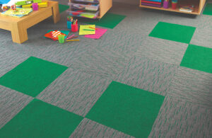 Green carpet tiles and striped green carpet tiles on the floor in a primary school